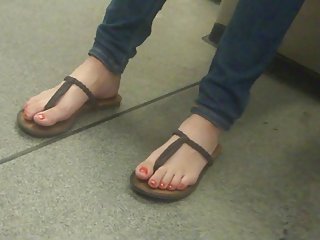 Los dedos del pie en sandalias de tiras