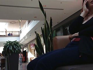 Aikuinen nainen istuu kauppakeskuksen penkillä